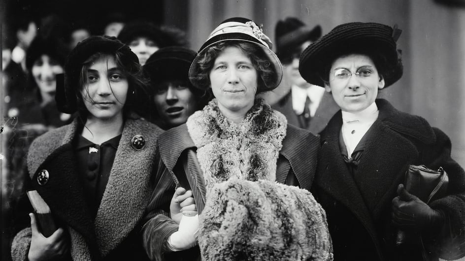  Optimized ALT text: An image of 4 suffragettes including Fola LaFolette link arms, to a soundtrack of music for Women’s History month.