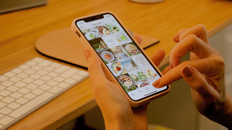  A person scrolls their instagram account on a smartphone, wondering, ‘how to get more followers on instagram?’