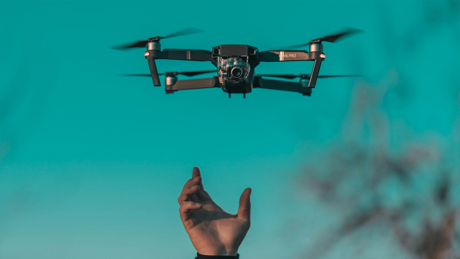   A drone hovers above the hand that launched it, capturing footage that will be augmented with royalty free drone sound effects.