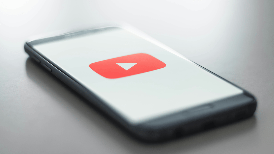  A smart phone loads the YouTube app, getting ready to create content using royalty free sound effects for YouTube shorts.