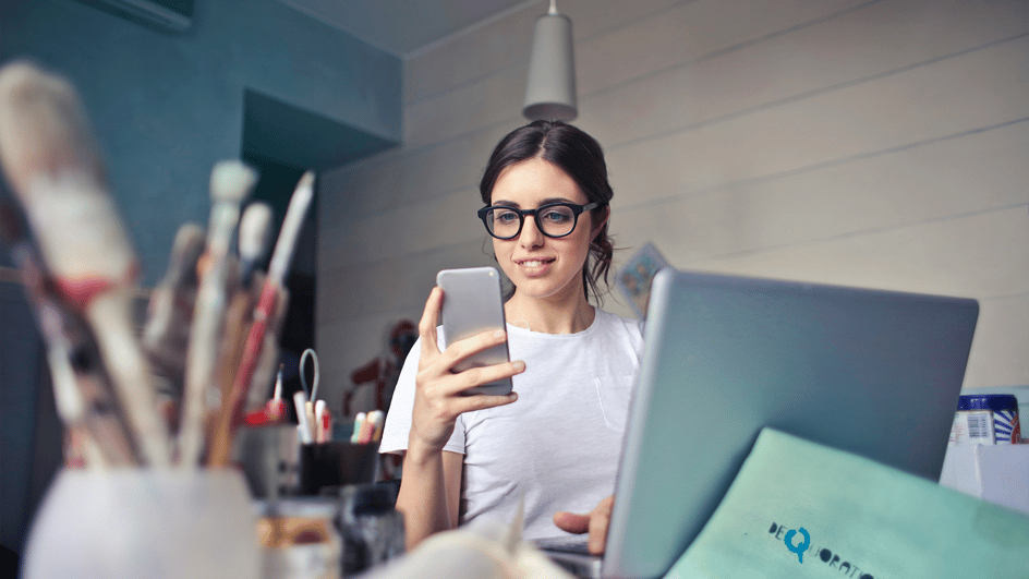  A woman in white shirt uses a smartphone, weighing the pros and cons of a creator vs business account instagram.