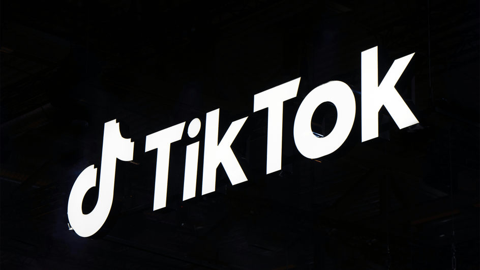  A white TikTok logo scrawls against a black background, as creators ask, “Should I make my TikTok a business account?”