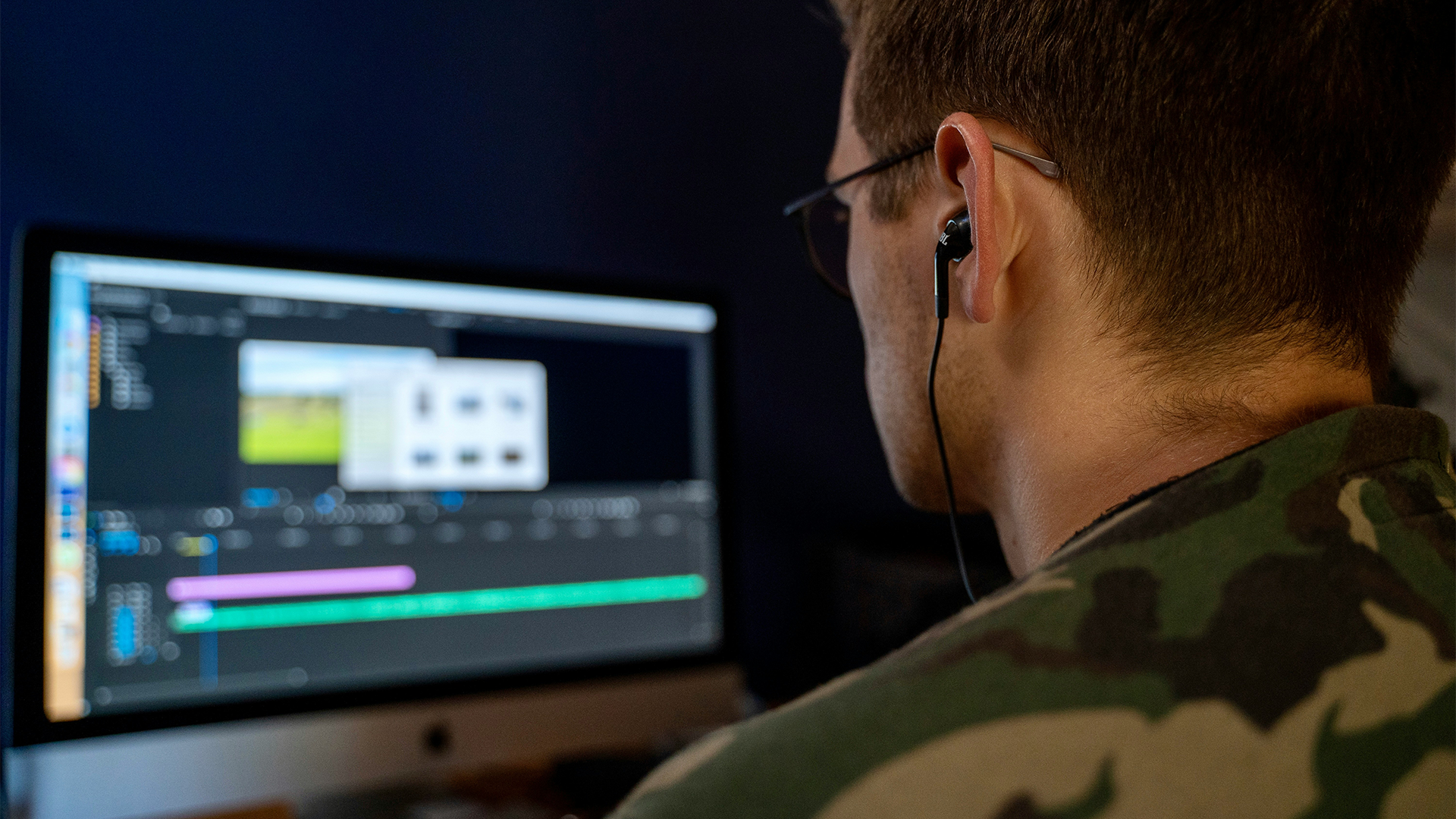 A content creator is looking at a computer screen, editing his video with the best audio plugin Premiere Pro has available