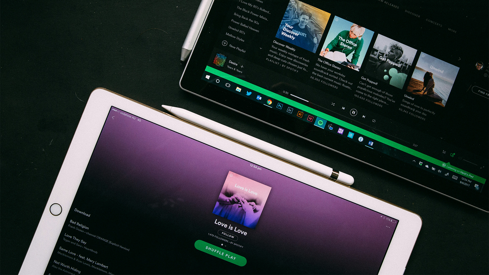 Two tablets sit side by side with the Spotify app open, as the users wonder, “How much does Spotify pay?”